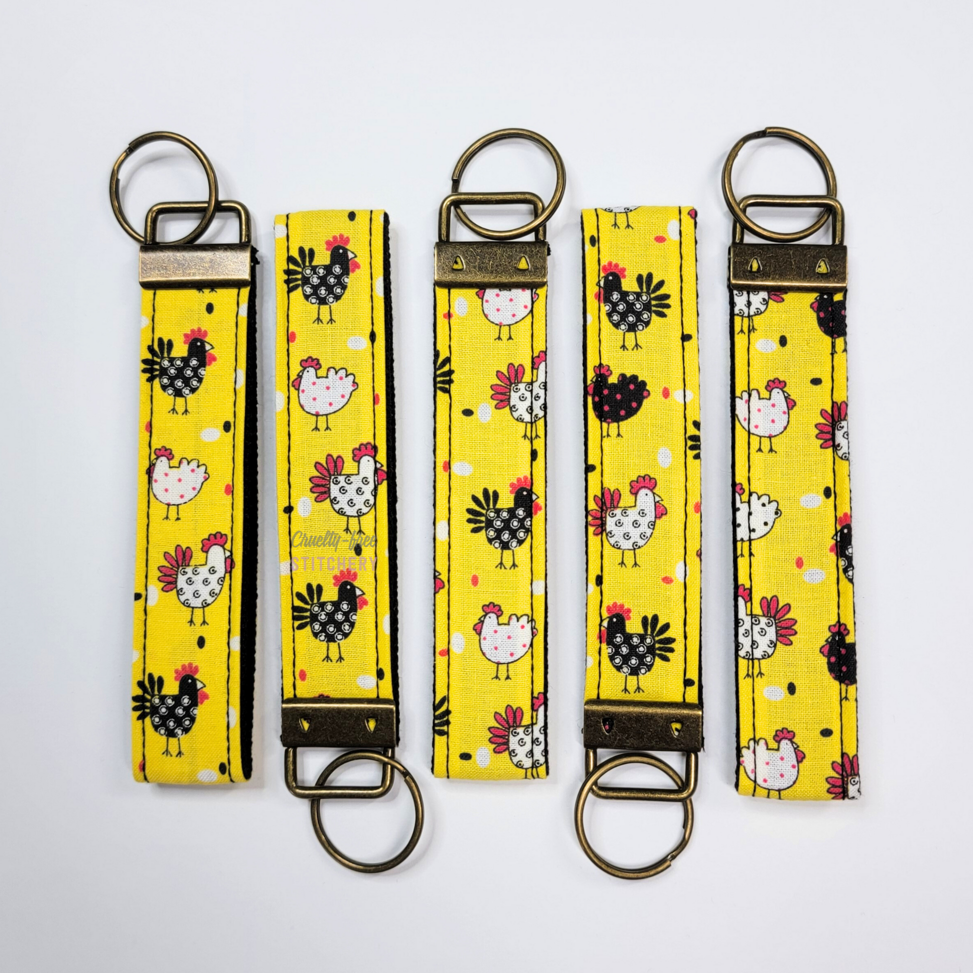 Five of the yellow with chickens key fobs lined up to show that the print may vary in placement.