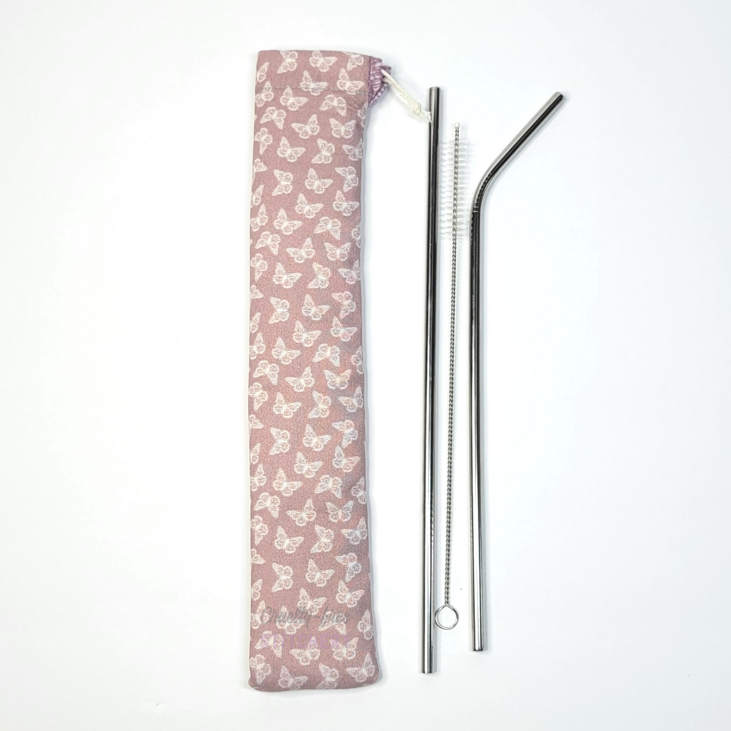 Reusable straw pouch in the same pink butterflies print laying vertically next to a straw cleaner brush, a straight stainless steel straw, and a bent stainless steel straw.