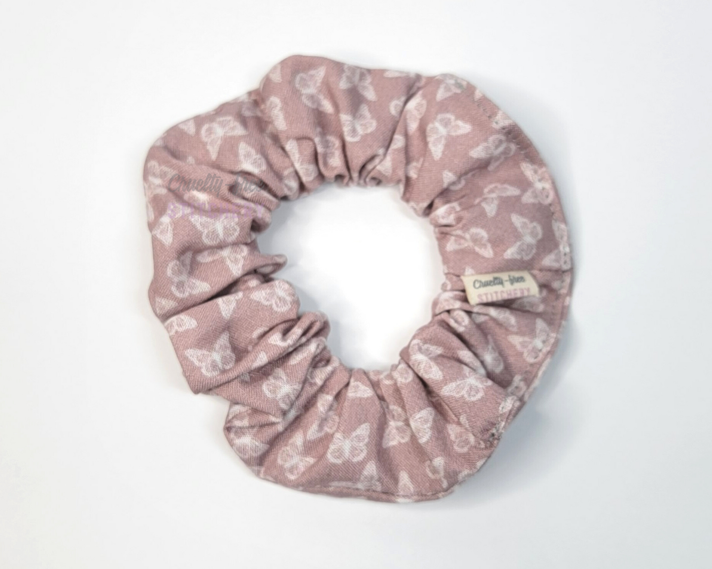 A muted mauve pink scrunchie with tiny white butterflies.