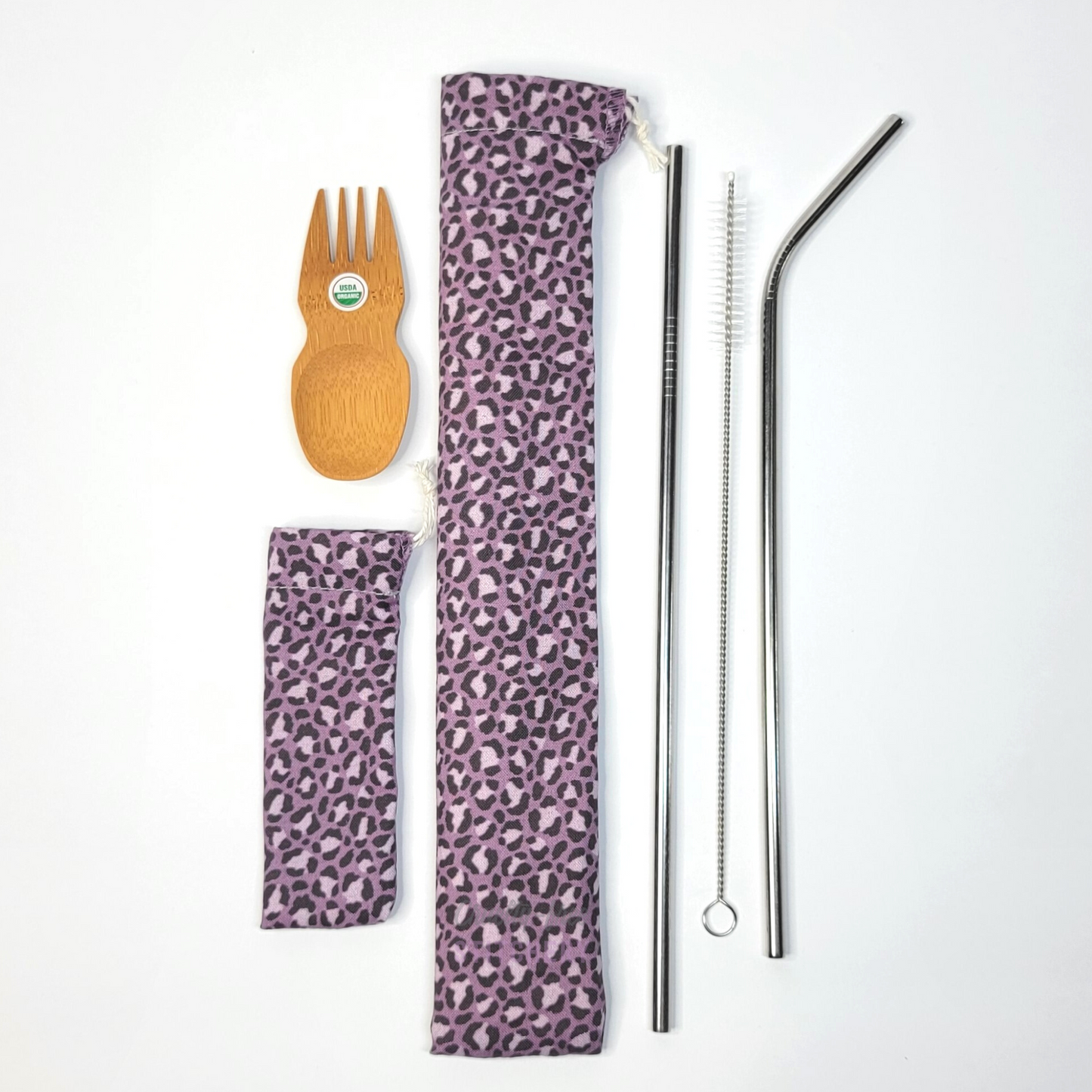 The contents of this bundle. A bamboo spork, violet leopard print spork pouch, violet leopard print straw pouch, and stainless steel straw set.