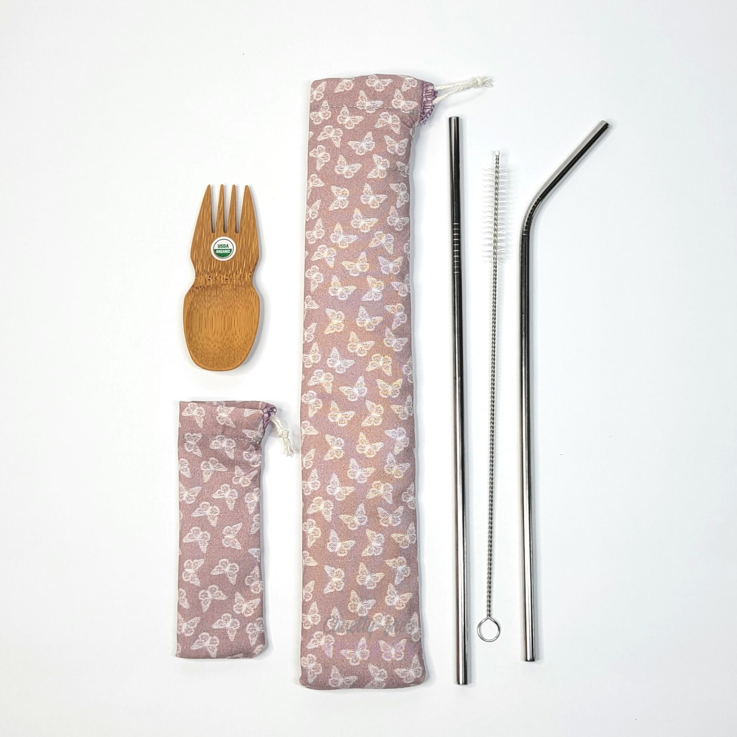 All contents of this bundle. A bamboo spork, mauve butterflies print spork pouch, mauve butterflies print straw pouch, and stainless steel straw set.