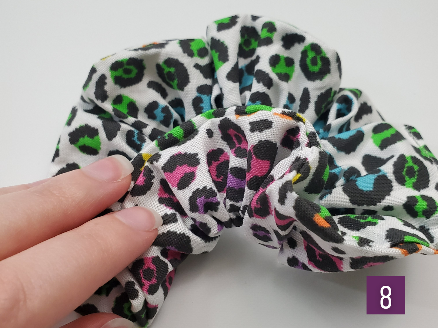 Print number 8 - a rainbow cheetah print. I am folding the scrunchie to show the rainbow continues all the way around. One side is more blue and green, the other is more pink and purple.