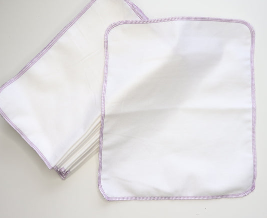 Solid white reusable NonPaper Towels. Stitched on the outside with a lilac purple thread.