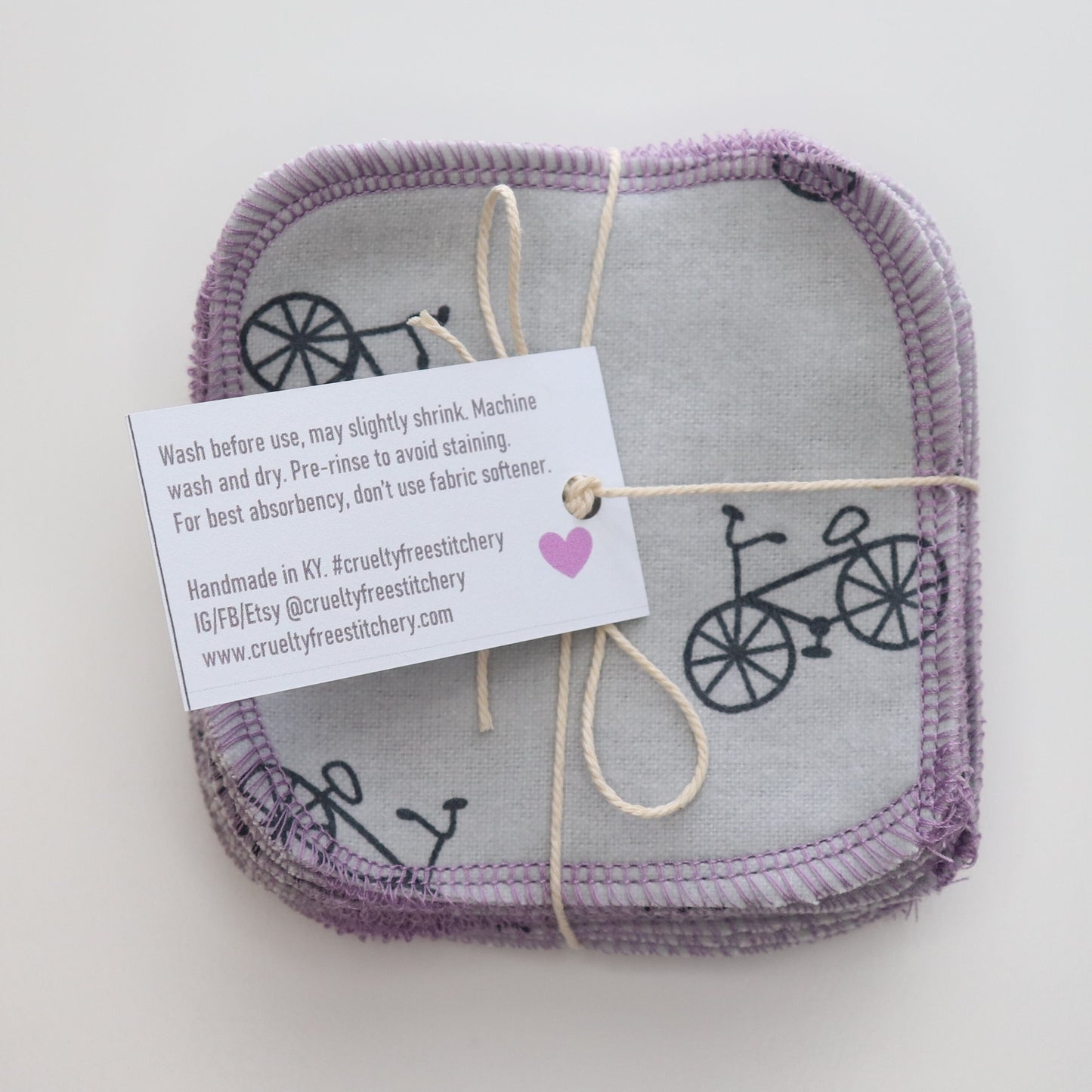 Bundled cotton rounds with the back of the tag showing, explaining care instructions.