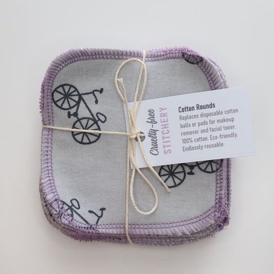 Grey with bicycles print cotton rounds in a bundle - tied with a thin white string like a gift and a small paper tag.