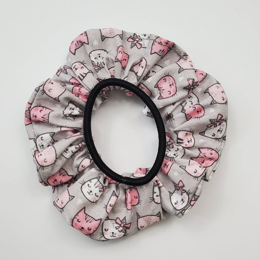 Grey and pink cats scrunchie shown with a black hair tie as a size comparison.