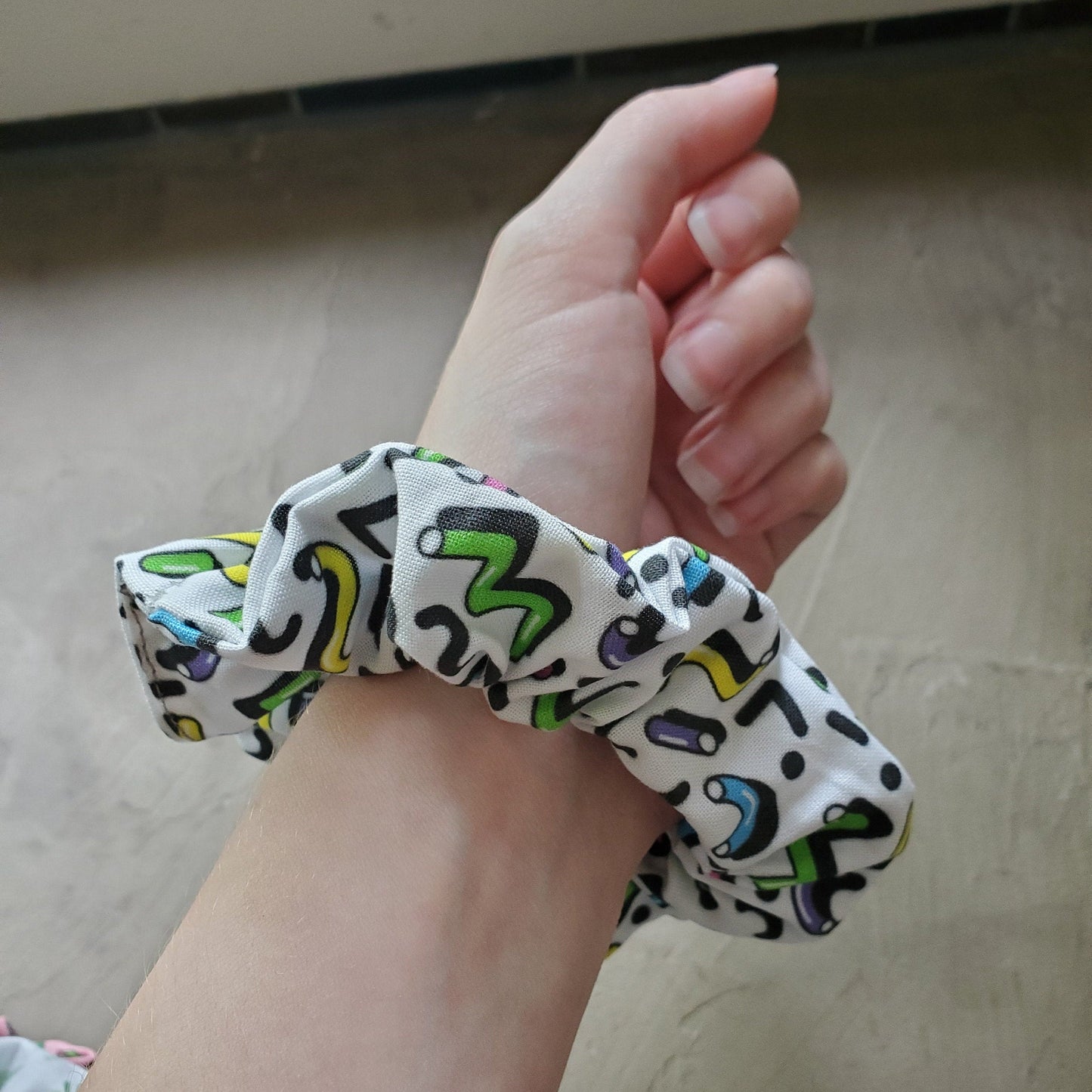 Scrunchie shown on my wrist for size reference. Fabric sticks out about an inch from the center of the scrunchie.