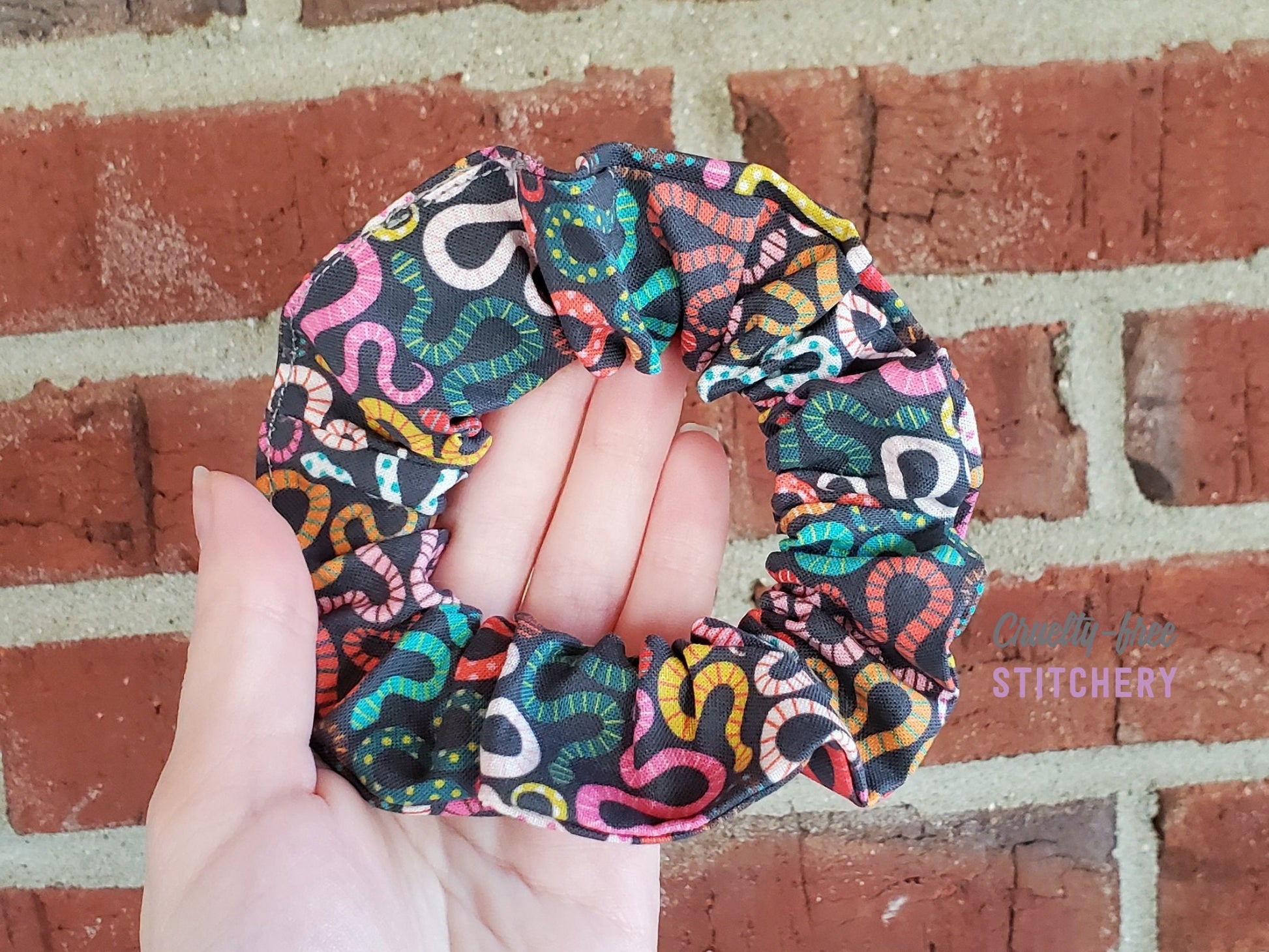 Black scrunchie with bright multicolored snakes. They look like squiggles until you get closer.