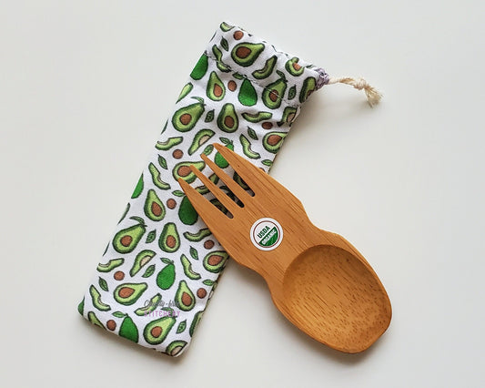 Avocado print reusable spork pouch. The pouch is sitting diagonally with the spork partially on top pointing the other way. The fork end of the spork is pointing to the left.