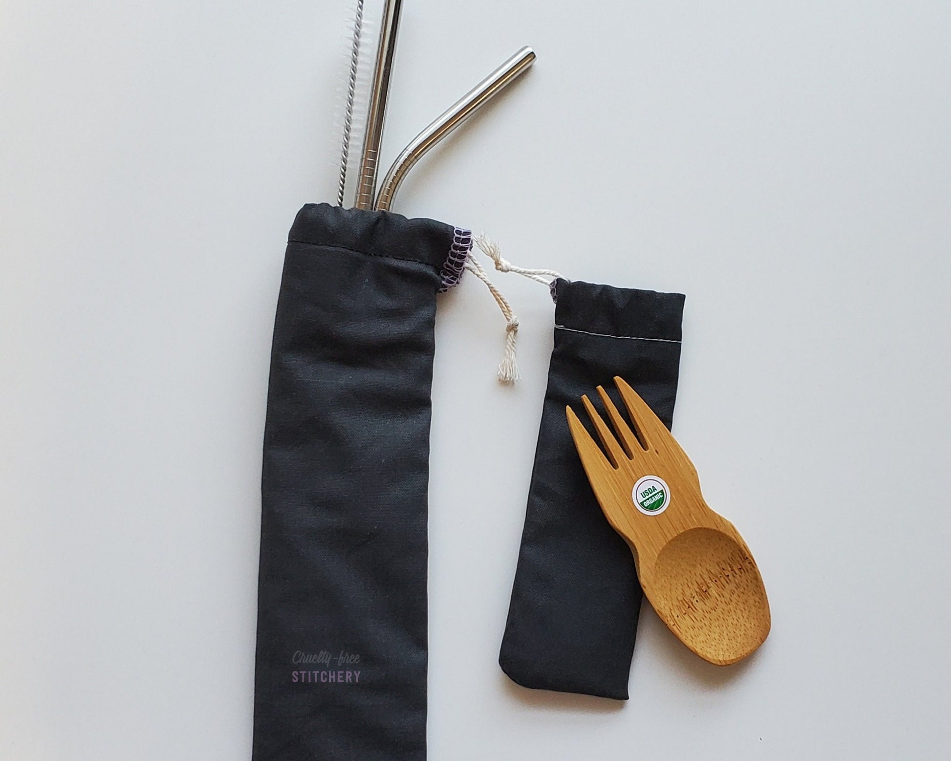 Reusable bamboo spork and stainless steel straw pouch set. The pouches are both solid black.