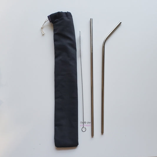 Solid black reusable straw pouch laying vertically next to a straw cleaner brush, a straight stainless steel straw, and a bent stainless steel straw.
