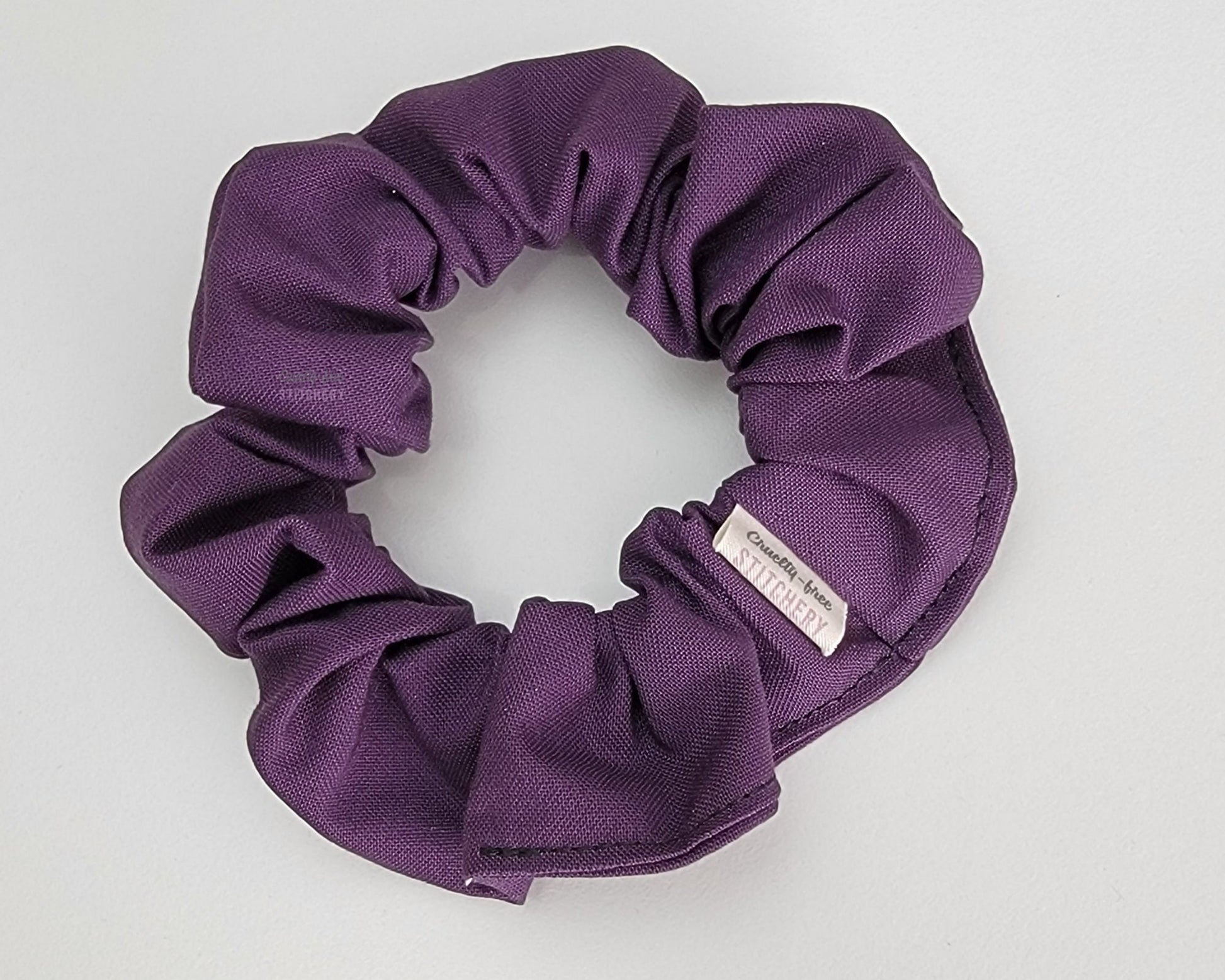 Solid eggplant purple scrunchie.
