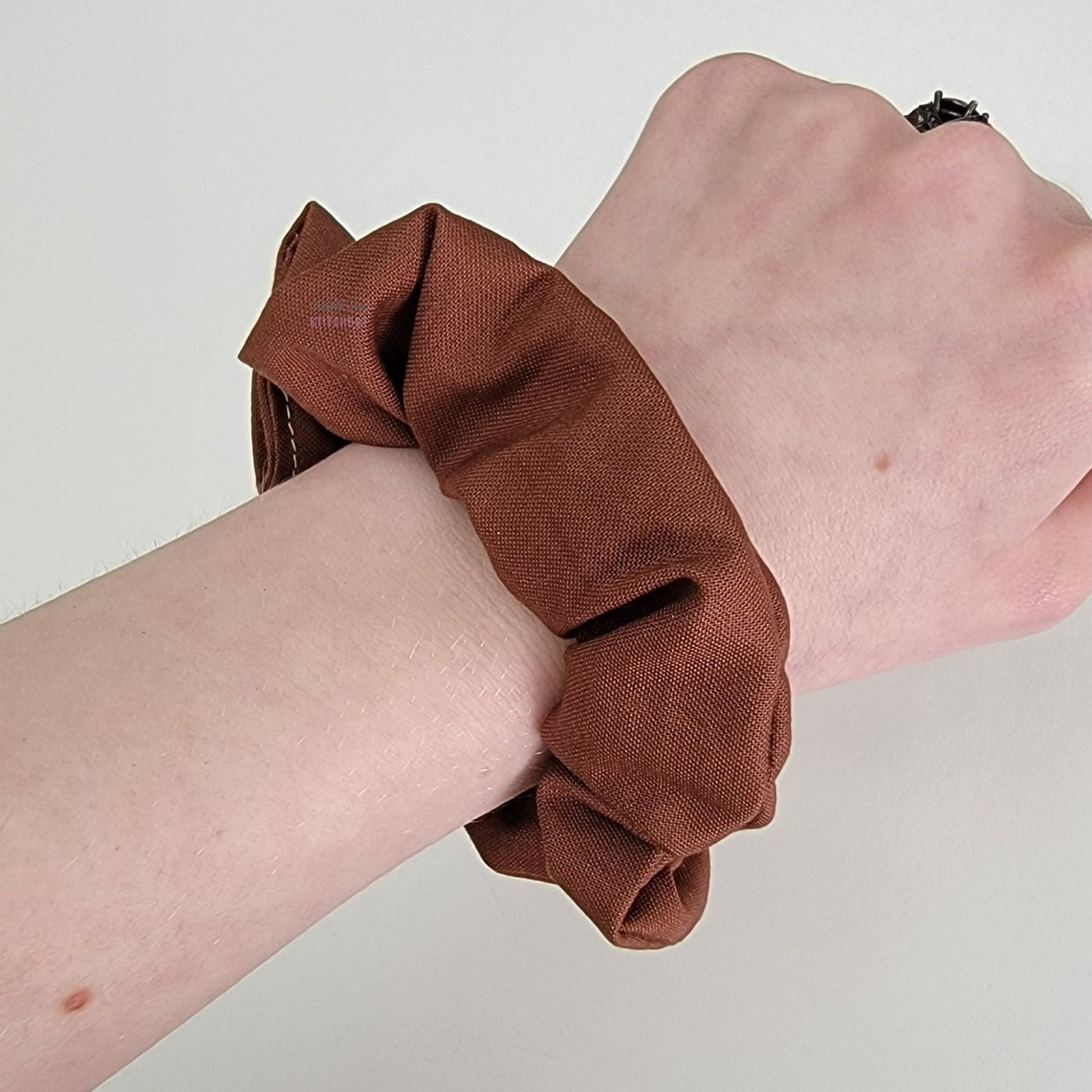 Solid chocolate brown scrunchie on my wrist.