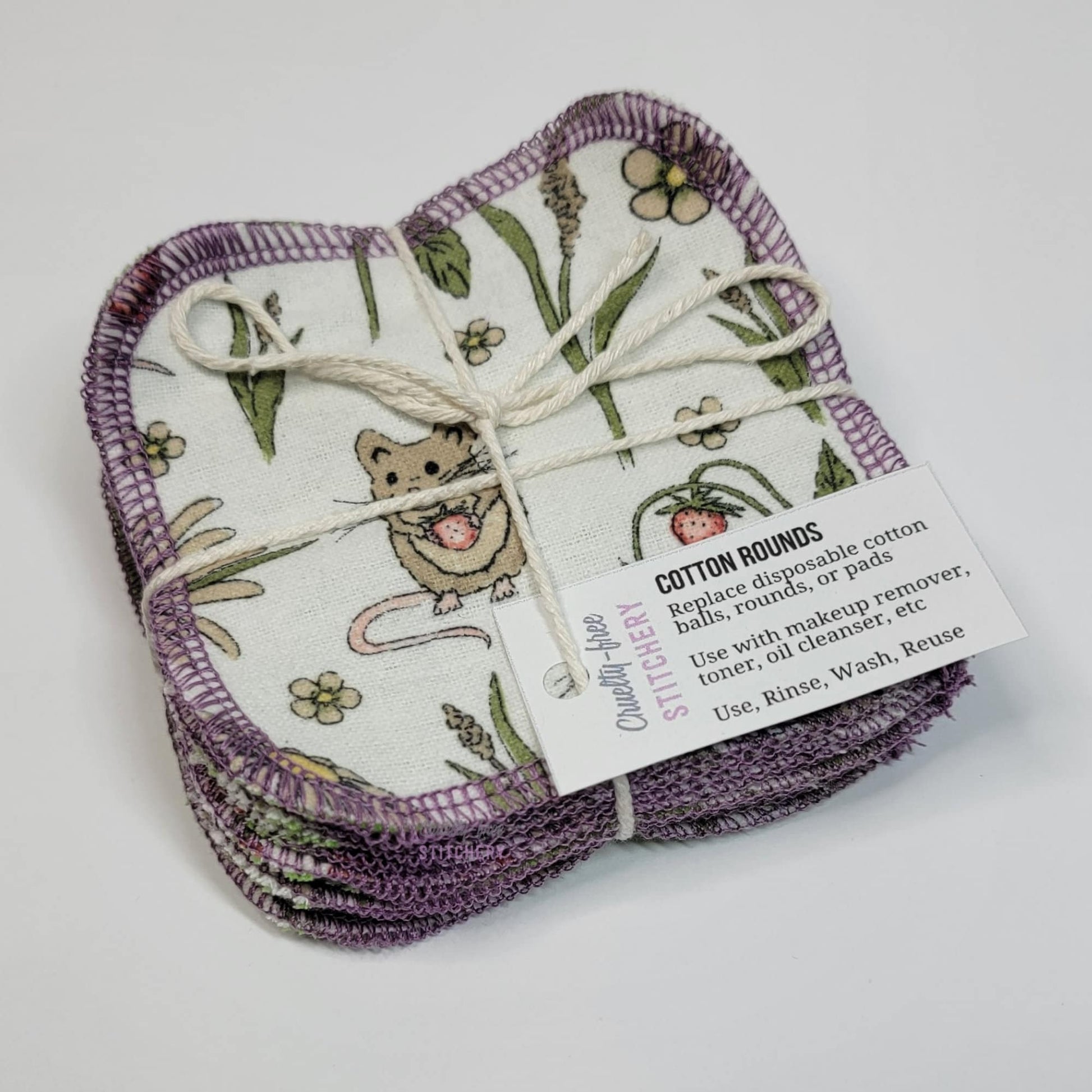 A bundled pack of reusable cotton rounds, tied with an off-white cotton string like a gift with a small white tag.