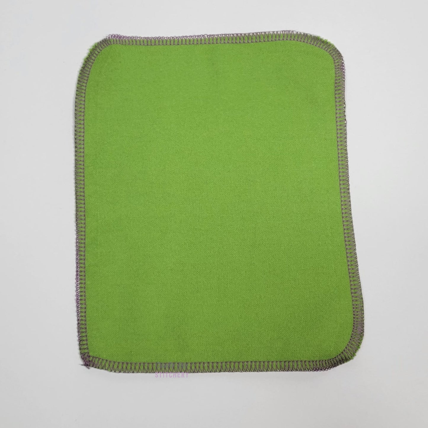 The back of a mouse cloth wipe, a light leaf green color.