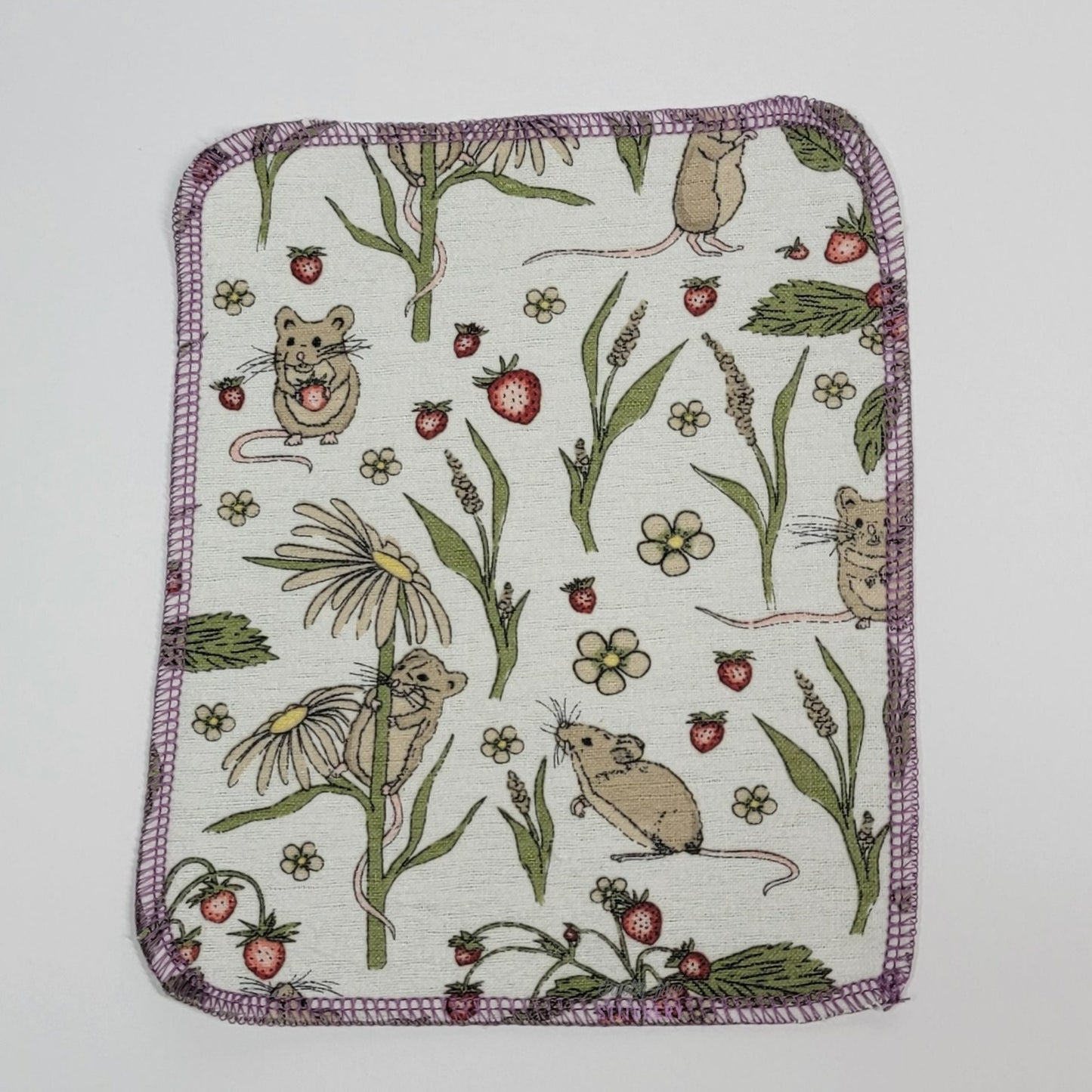 The front of one mouse print cloth wipe. It is a rounded rectangular shape with lilac purple stitching around the edges.